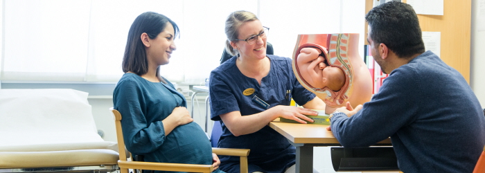 Barnmorska på barnmorskemottagning visar en bebis placering i livmodern.